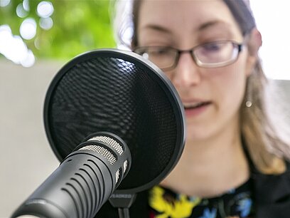 Podcast-Sprecherin am Mikrofon